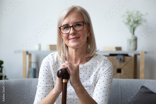Konstfotografi Head shot portrait beautiful older woman in glasses with cane