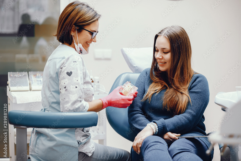 Girl talking to the dendist. Beautiful lady in the dentist's office. Woman in a uniform Girl talking to the dendist. Beautiful lady in the dentist's office. Woman in a uniform