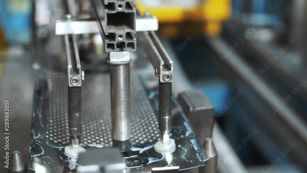 Robotic manipulator moving perforated metal sheets for washing drum at factory Robotic manipulator moving perforated metal sheets for washing drum at factory