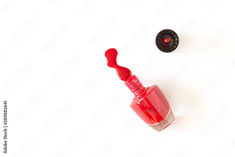 Red Nail polish flowing from the bottle. Close up of a nail polish bottle on white background. Red Nail polish flowing from the bottle. Close up of a nail polish bottle on white background.