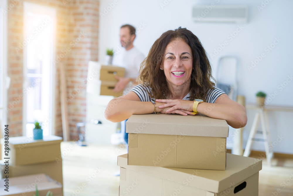 Middle age senior couple moving to a new house, woman smiling happy in love with new apartment Middle age senior couple moving to a new house, woman smiling happy in love with new apartment