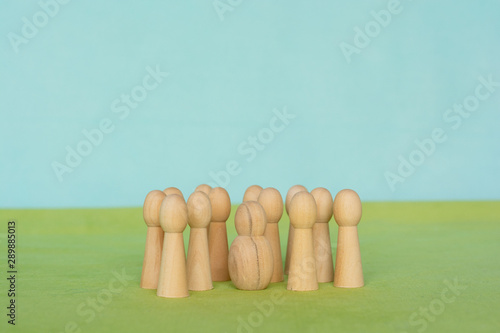 Group of little figurines surounding a singel, different looking figurine photo