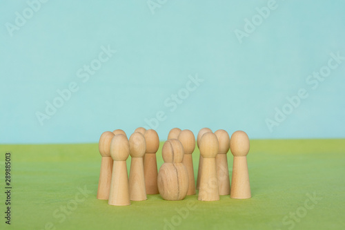 Group of little figurines surounding a singel, different looking figurine