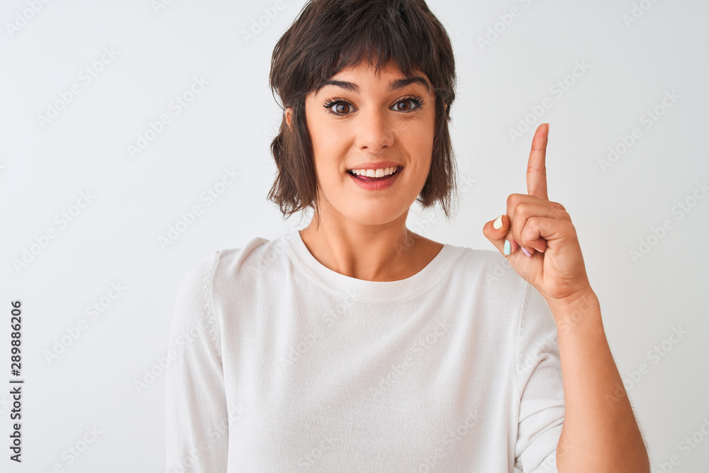 Young beautiful woman wearing casual t-shirt standing over isolated white background surprised with an idea or question pointing finger with happy face, number one Young beautiful woman wearing casual t-shirt standing over isolated white background surprised with an idea or question pointing finger with happy face, number one
