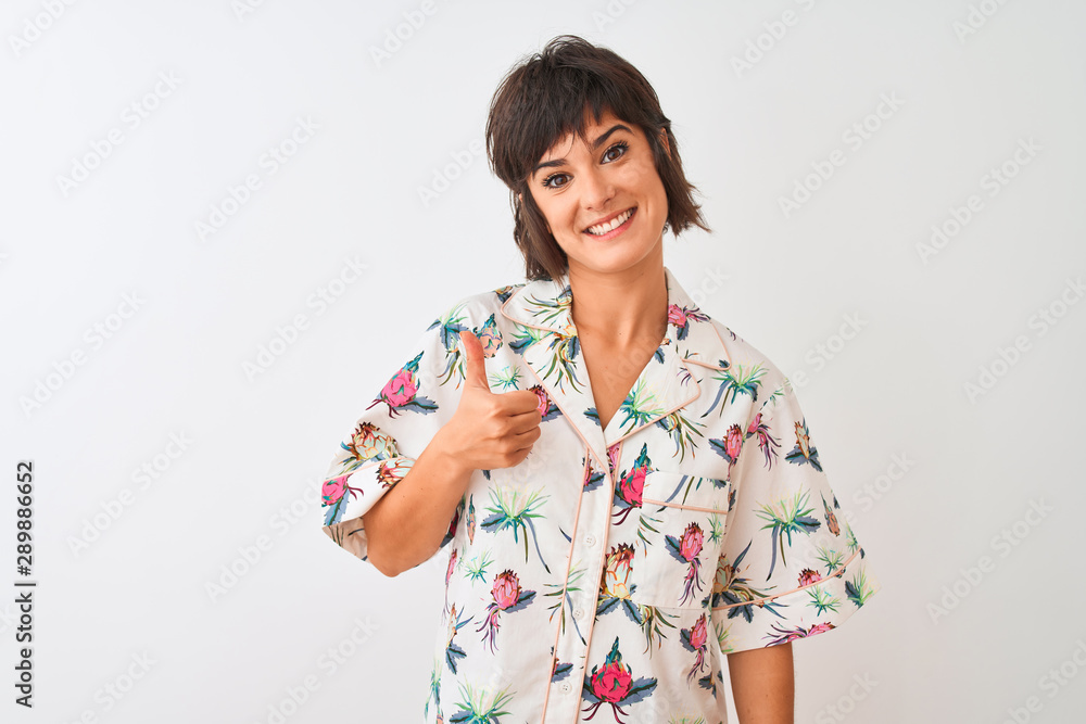 Beautiful woman on vacation wearing summer casual shirt over isolated white background doing happy thumbs up gesture with hand. Approving expression looking at the camera with showing success. Beautiful woman on vacation wearing summer casual shirt over isolated white background doing happy thumbs up gesture with hand. Approving expression looking at the camera with showing success.