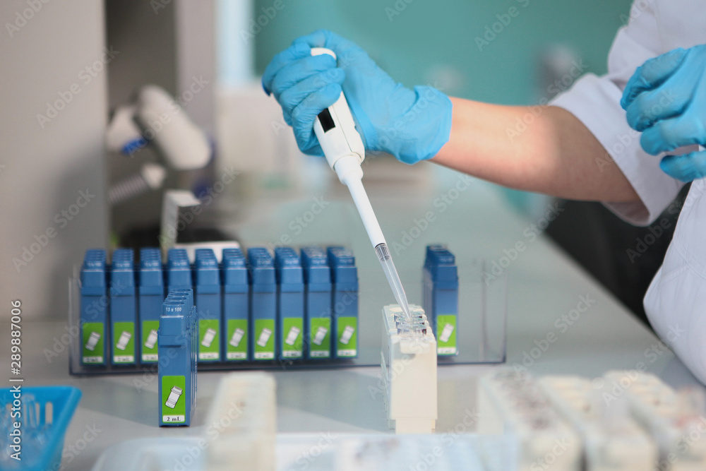 Laboratory assistant hand with test tubes and cartridges. medical research concept. Diagnosis. Photo in the interior. Macro photo. Laboratory assistant hand with test tubes and cartridges. medical research concept. Diagnosis. Photo in the interior. Macro photo.