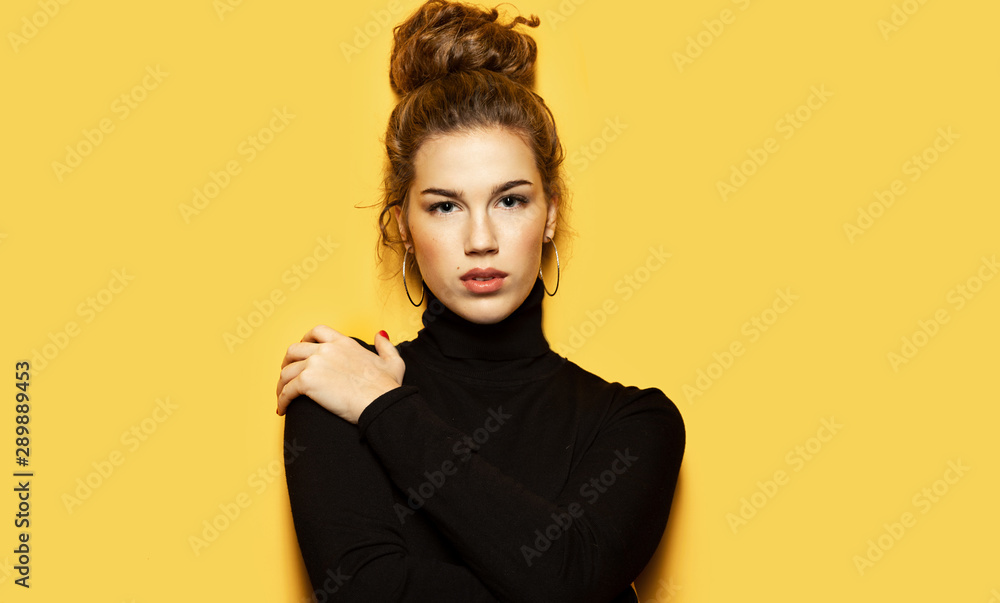 Portrait of georgeous girl posing for fashion photoshoot on yellow  background. Pretty model dressed in stylish black pullover. Trend and  lifestyle concept Stock Photo | Adobe Stock