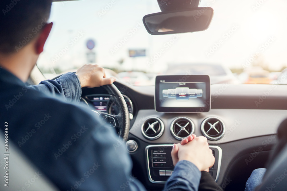 Image of driver man and girl sitting in front seat of car.