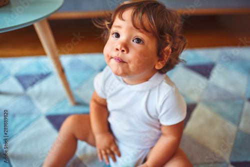 Beautiful toddler child girl wearing white t-shirt playing on the carpet