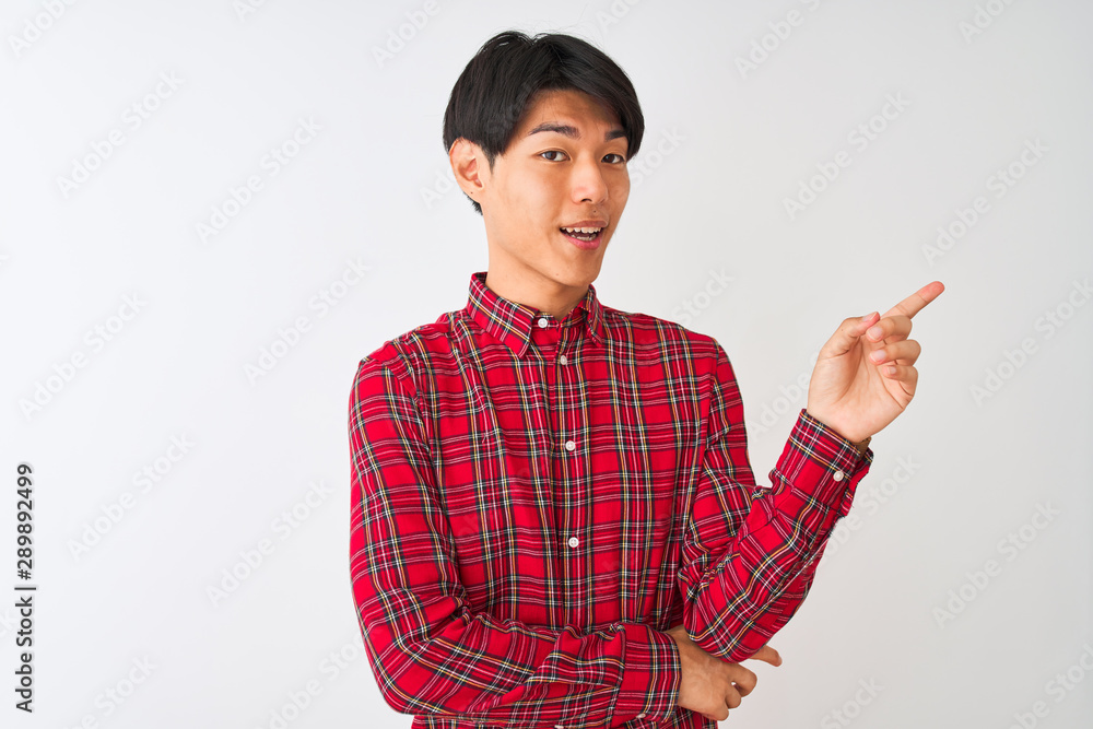 Young chinese man wearing casual red shirt standing over isolated white background with a big smile on face, pointing with hand and finger to the side looking at the camera. Young chinese man wearing casual red shirt standing over isolated white background with a big smile on face, pointing with hand and finger to the side looking at the camera.