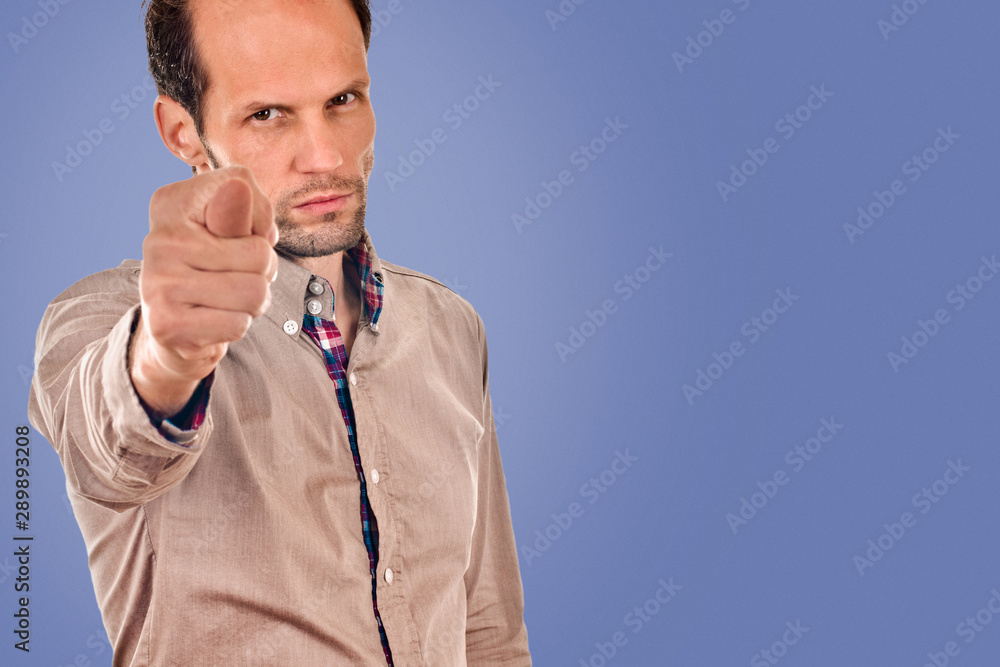 young man shows sign fig on blue color background young man shows sign fig on blue color background