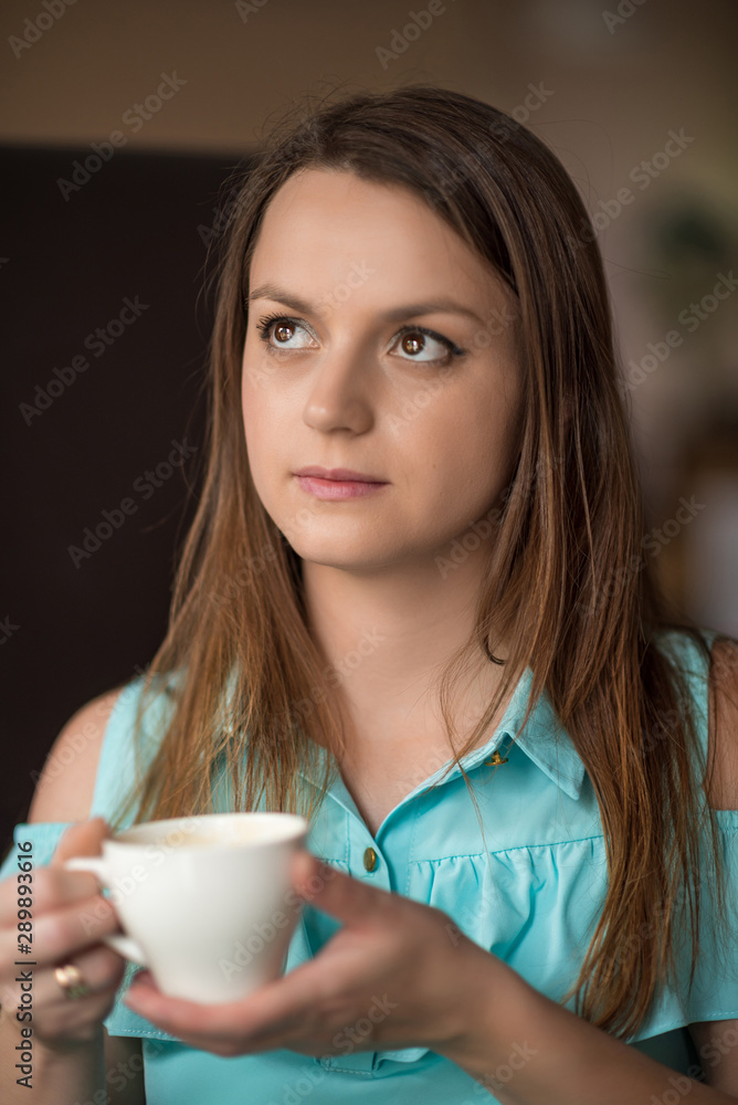 Young beautiful girl is drinking coffee in a cafe. Young beautiful girl is drinking coffee in a cafe.