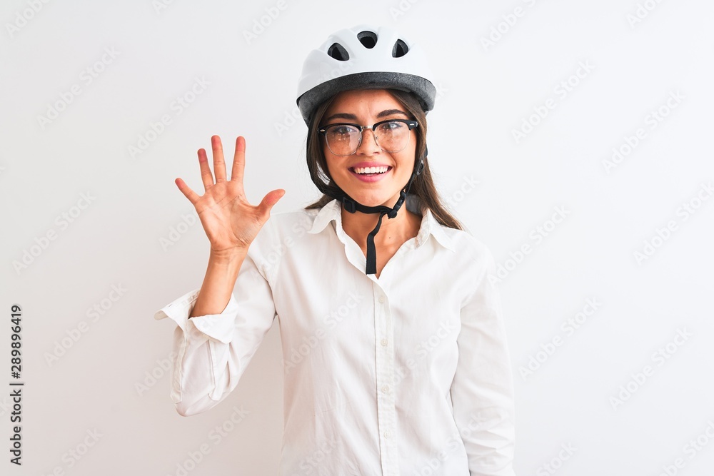 Beautiful businesswoman wearing glasses and bike helmet over isolated white background showing and pointing up with fingers number five while smiling confident and happy. Beautiful businesswoman wearing glasses and bike helmet over isolated white background showing and pointing up with fingers number five while smiling confident and happy.