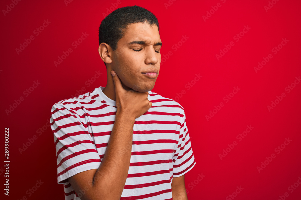 Young handsome arab man wearing striped t-shirt over isolated red background Touching painful neck, sore throat for flu, clod and infection Young handsome arab man wearing striped t-shirt over isolated red background Touching painful neck, sore throat for flu, clod and infection