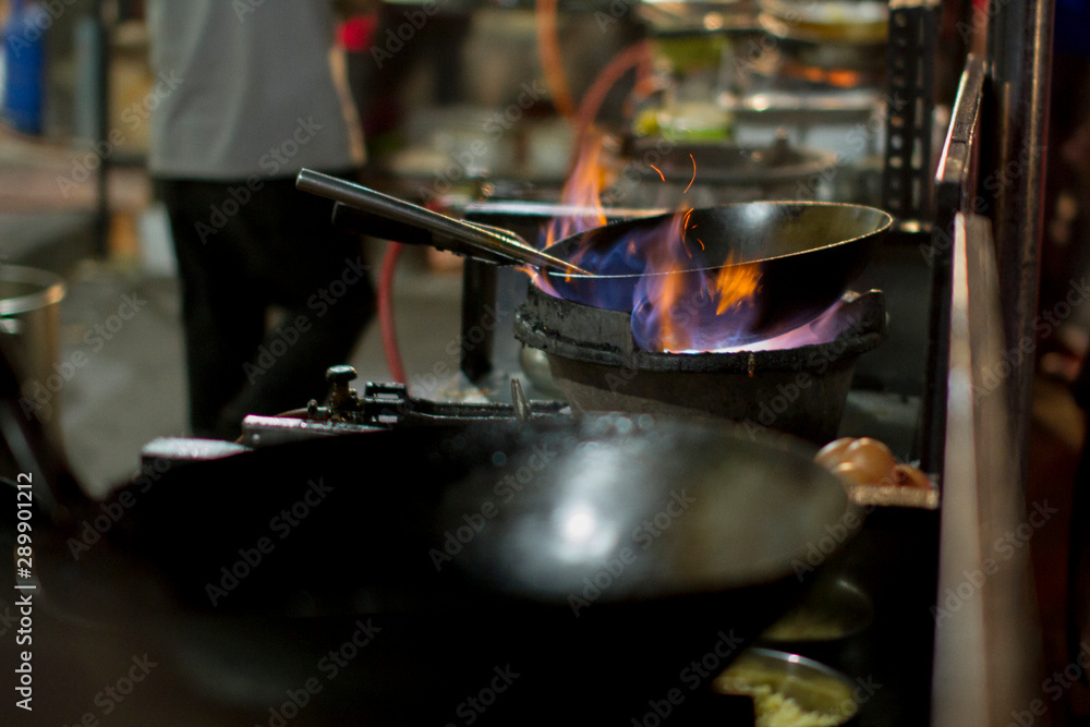 The chef heats up the oil in the wok ready for cooking The chef heats up the oil in the wok ready for cooking