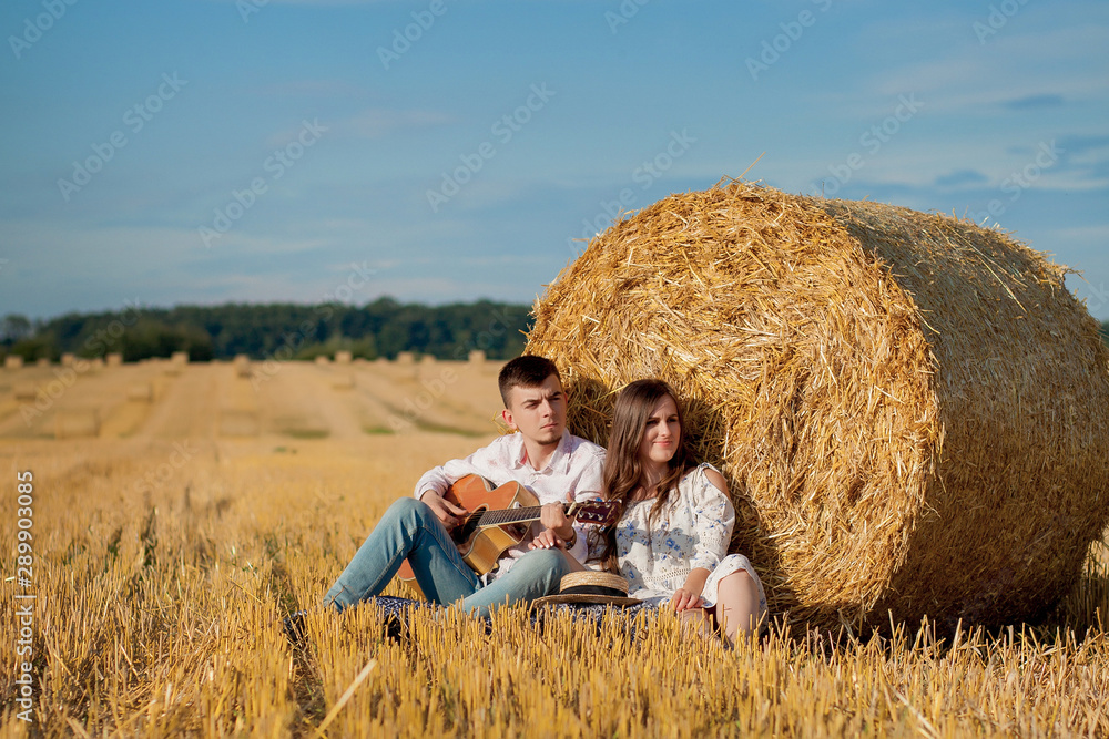Happy young couple on straw, romantic people concept, beautiful landscape, summer season Happy young couple on straw, romantic people concept, beautiful landscape, summer season
