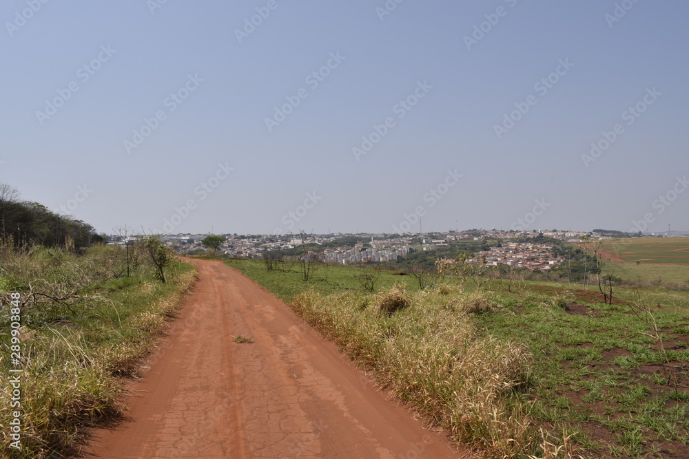 Estrada de terra através de zona rural
