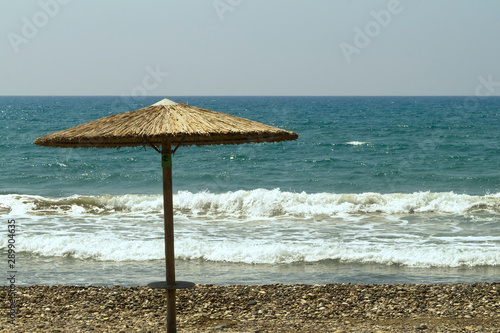 Fototapeta Naklejka Na Ścianę i Meble -  Straw umbrella in front of stormy sea