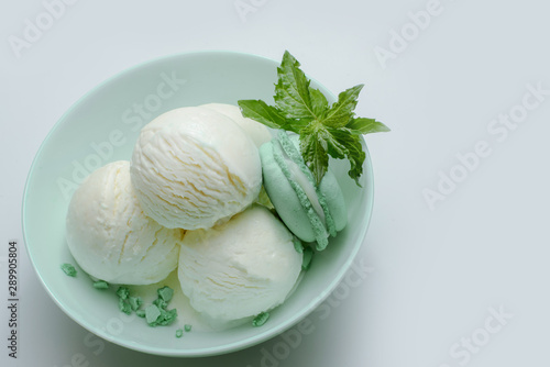 Balls of fresh ice cream with a sprig of mint and mint macaroon.