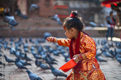 Foto Little girl dressed as Kumari God feeding the pigeons at Kathmandu Durbar Square