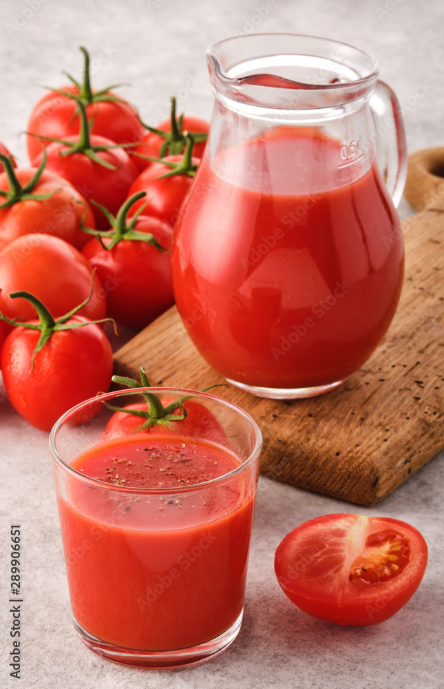 Tasty Tomato juice in a glass with ripe red tomatoes. Tasty Tomato juice in a glass with ripe red tomatoes.