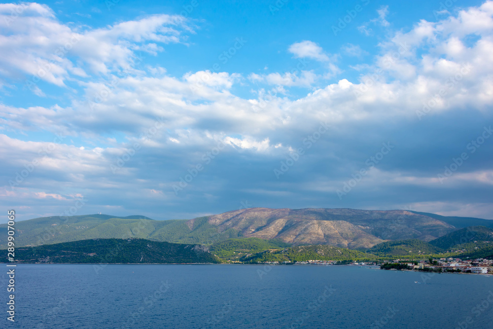 Picturesque landscape with dark blue clouds, mountains and sea Picturesque landscape with dark blue clouds, mountains and sea