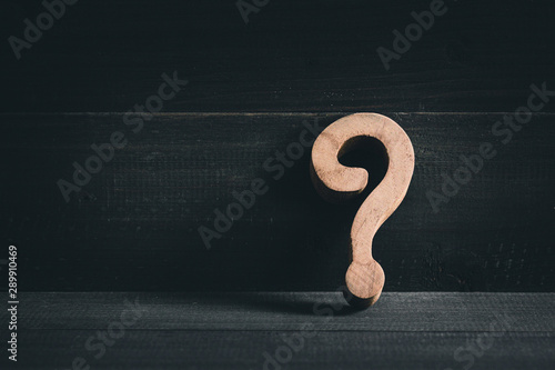 Wooden question mark on wood table background. Problem solving concept.
