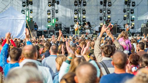 Foto many different people at a concert listening to rock band music open air