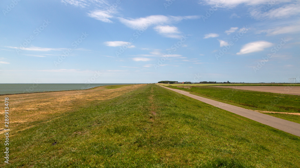 Obraz premium Typical rural landscape with dike of southwestern part of Dutch province Friesland