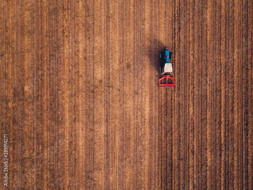 Obraz na plátně Aerial view of agricultural tractor doing stubble tillage