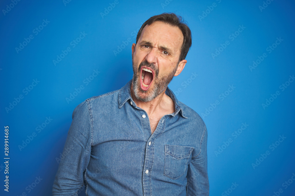 Handsome middle age senior man with grey hair over isolated blue background In shock face, looking skeptical and sarcastic, surprised with open mouth Handsome middle age senior man with grey hair over isolated blue background In shock face, looking skeptical and sarcastic, surprised with open mouth