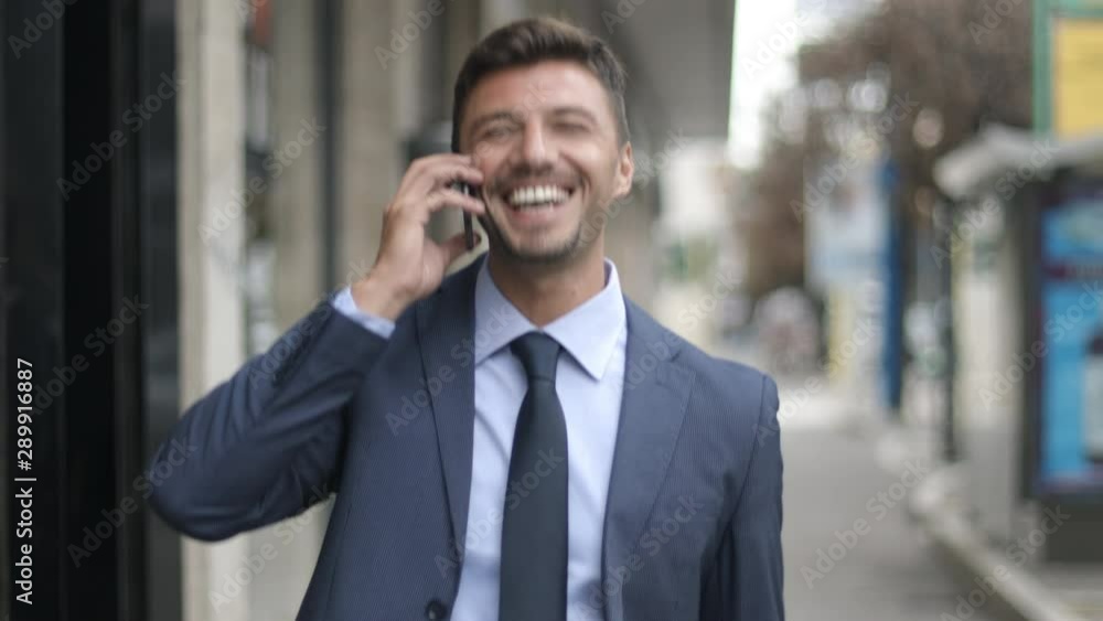Happy handsome bearded young businessman in blue jacket, tie and briefcase talking happily on thephone. Business, goal and success at work. Happy handsome bearded young businessman in blue jacket, tie and briefcase talking happily on thephone. Business, goal and success at work.