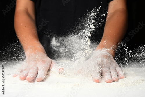 Women's hands hit the table with flour