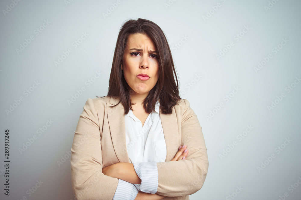 Young beautiful elegant business woman over isolated background skeptic and nervous, disapproving expression on face with crossed arms. Negative person. Young beautiful elegant business woman over isolated background skeptic and nervous, disapproving expression on face with crossed arms. Negative person.