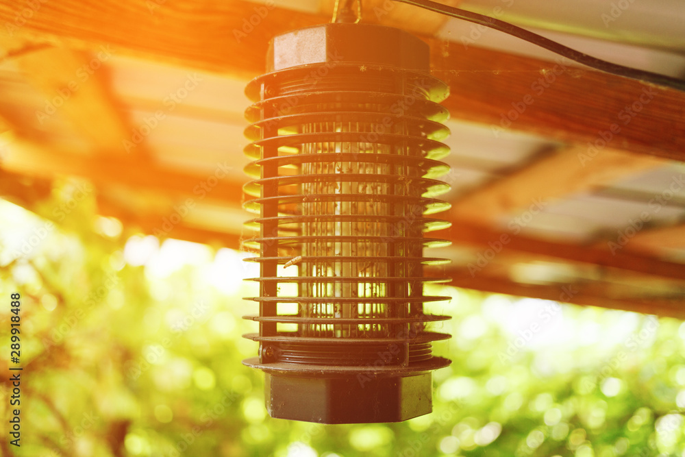 Electric mosquito trap in sunlight rays. - obrazy, fototapety, plakaty 