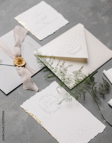 Wedding details flat lay. Wedding invitation and scroll paper. Bottle with fragrance. Ring box. Simple bouquet.