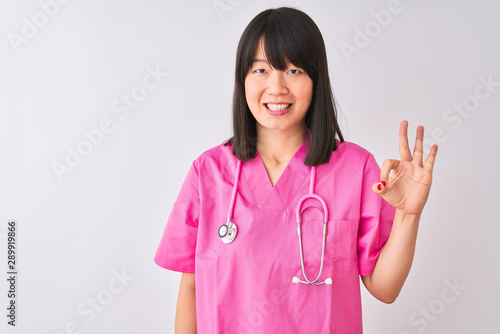 Young beautiful Chinese nurse woman wearing stethoscope over isolated white background showing and pointing up with fingers number three while smiling confident and happy.