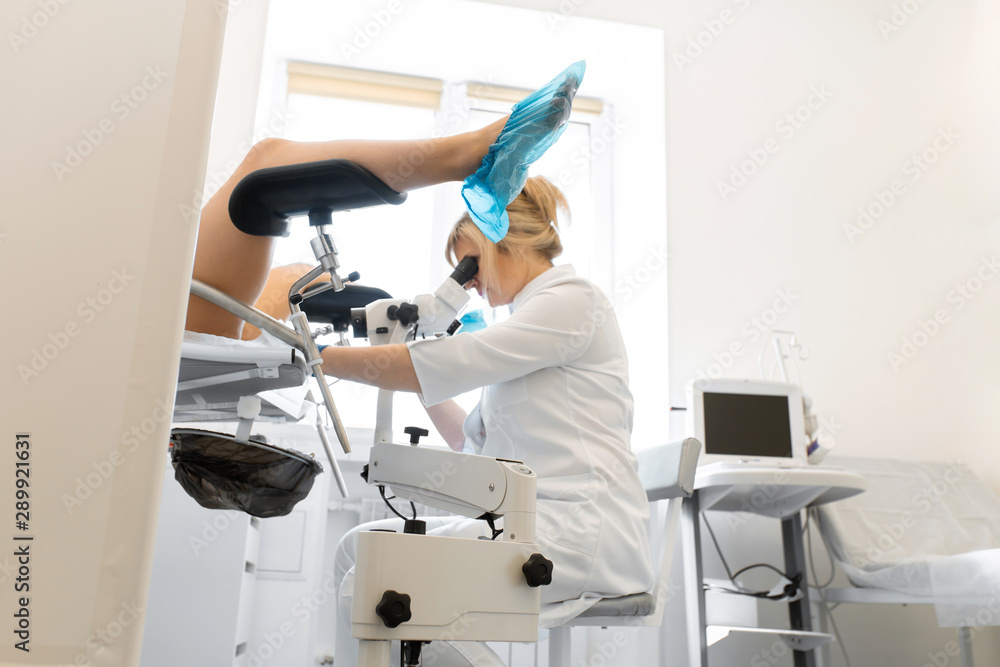 A gynecologist examines a patient on a gynecological chair. Workflow of a gynecologist