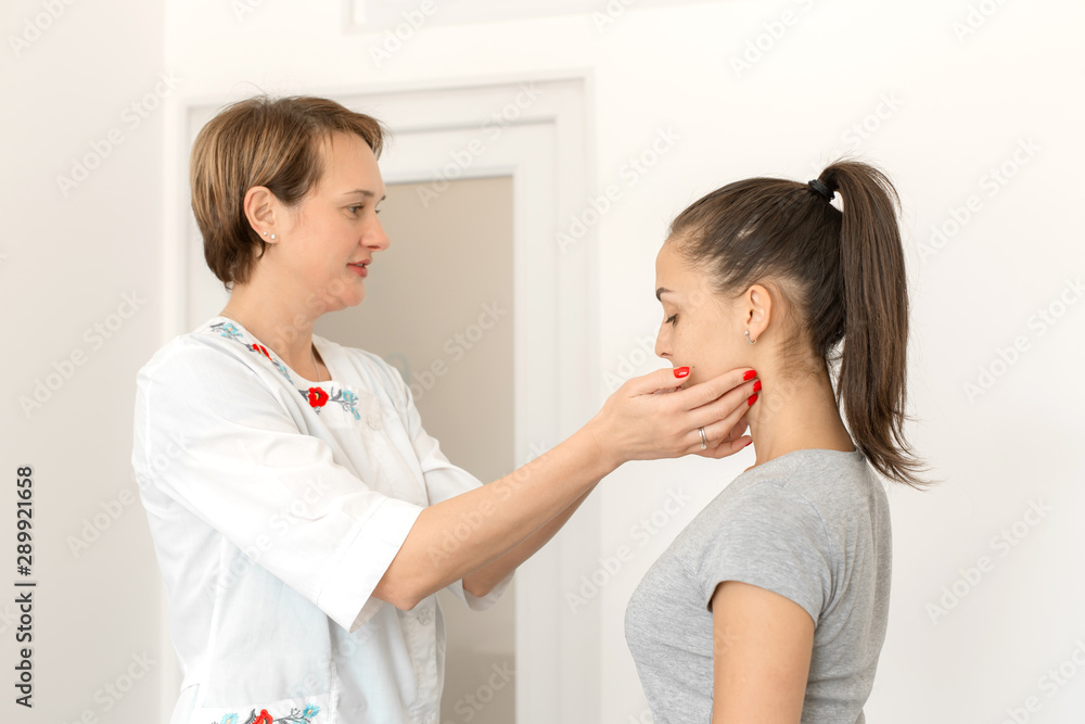 Therapist examines a young girl patient. Throat in neck, thyroid enlargement Therapist examines a young girl patient. Throat in neck, thyroid enlargement
