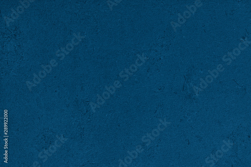 Navy blue colored dark Concrete textured background with roughness and irregularities to your design or product. Color trend concept.