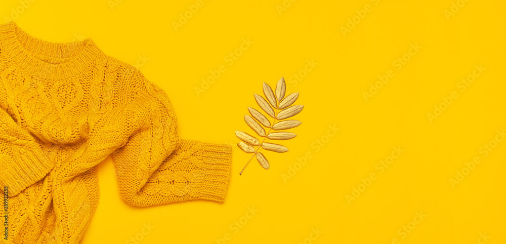 Autumn flat lay composition. Orange yellow knitted woolen female sweater and golden leaves on yellow background top view. Fashionable women's fall accessories. Cozy Knit Jumper Stylish Lady Clothes - obrazy, fototapety, plakaty 