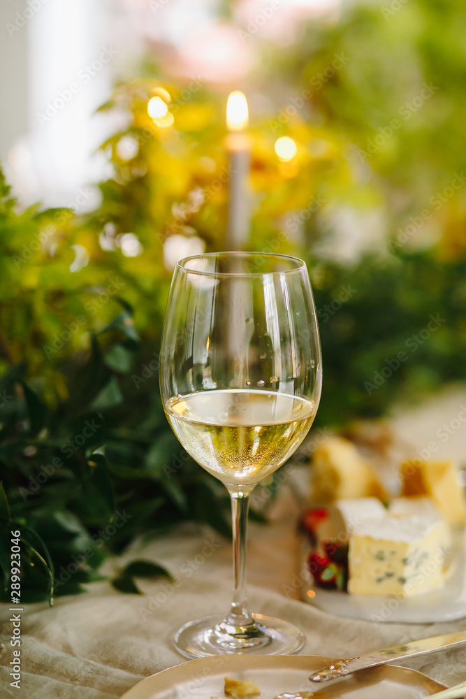 Wine in glass on table with candle light on background Wine in glass on table with candle light on background