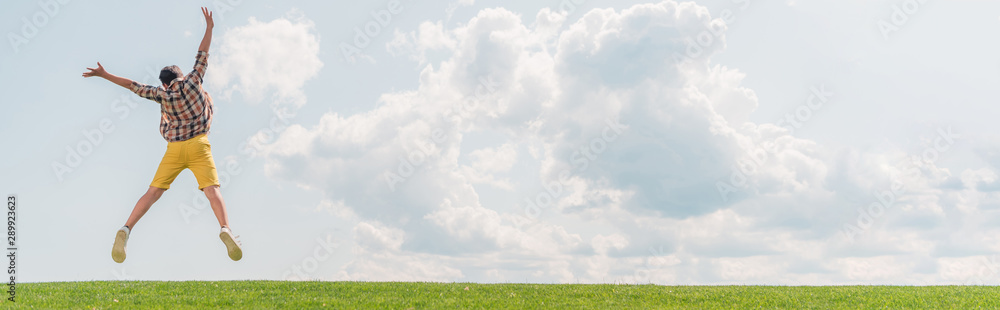 panoramic shot of boy jumping and gesturing against blue sky panoramic shot of boy jumping and gesturing against blue sky