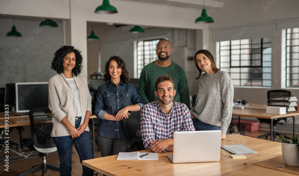 Diverse team of smiling designers working together in an office Diverse team of smiling designers working together in an office