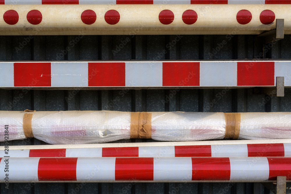stored railway barriers and bars in red and white mounted on a wall stored railway barriers and bars in red and white mounted on a wall