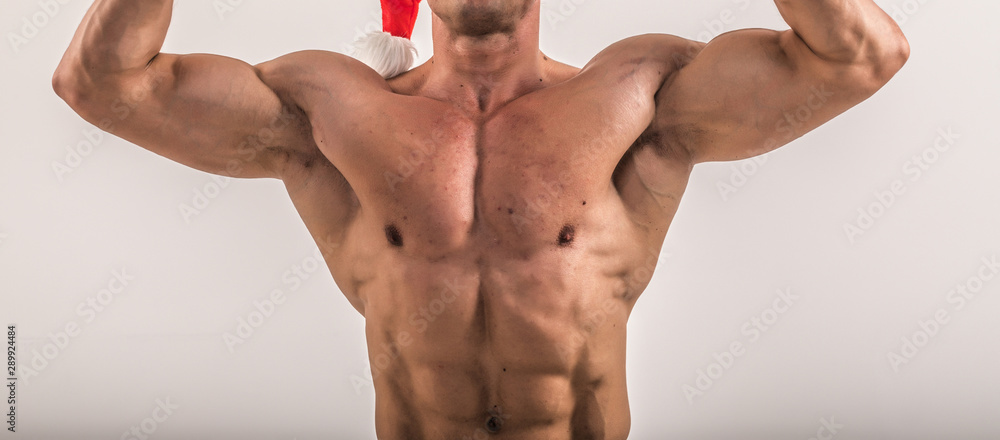 Fototapeta premium torso of attractive male body builder on blue background. Bodybuilder flexing his muscles in studio