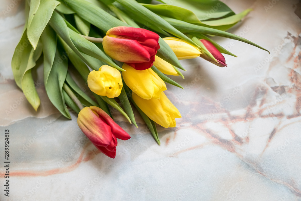 Obraz premium Beautiful tulips for Mother's Day on marble background, side view.International Women's Day.Bouquet of beautiful spring tulips. Fresh colorful tulip flowers on stone table.