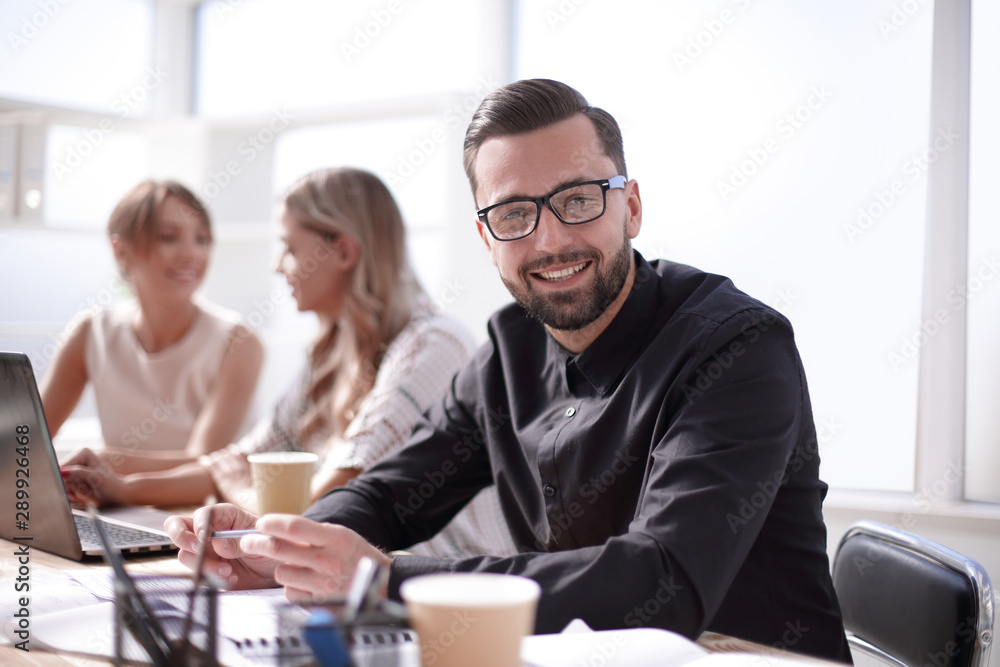 smiling businessman in the workplace in the office smiling businessman in the workplace in the office