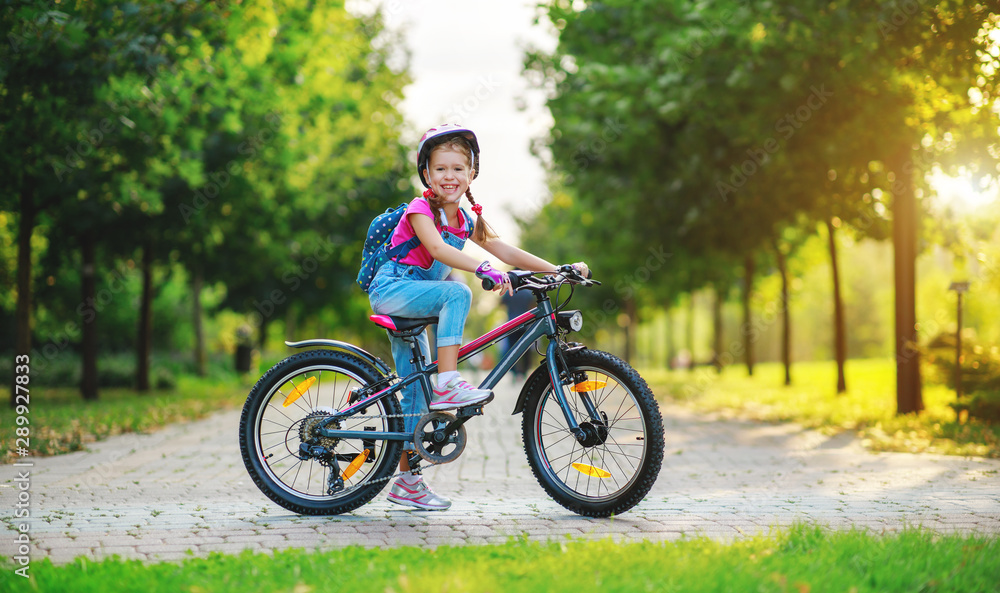 happy cheerful child girl riding a bike in Park in nature. happy cheerful child girl riding a bike in Park in nature.