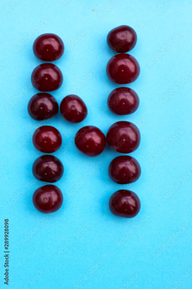 Letter N fresh cherry alphabet blue color flat lay Letter N fresh cherry alphabet blue color flat lay